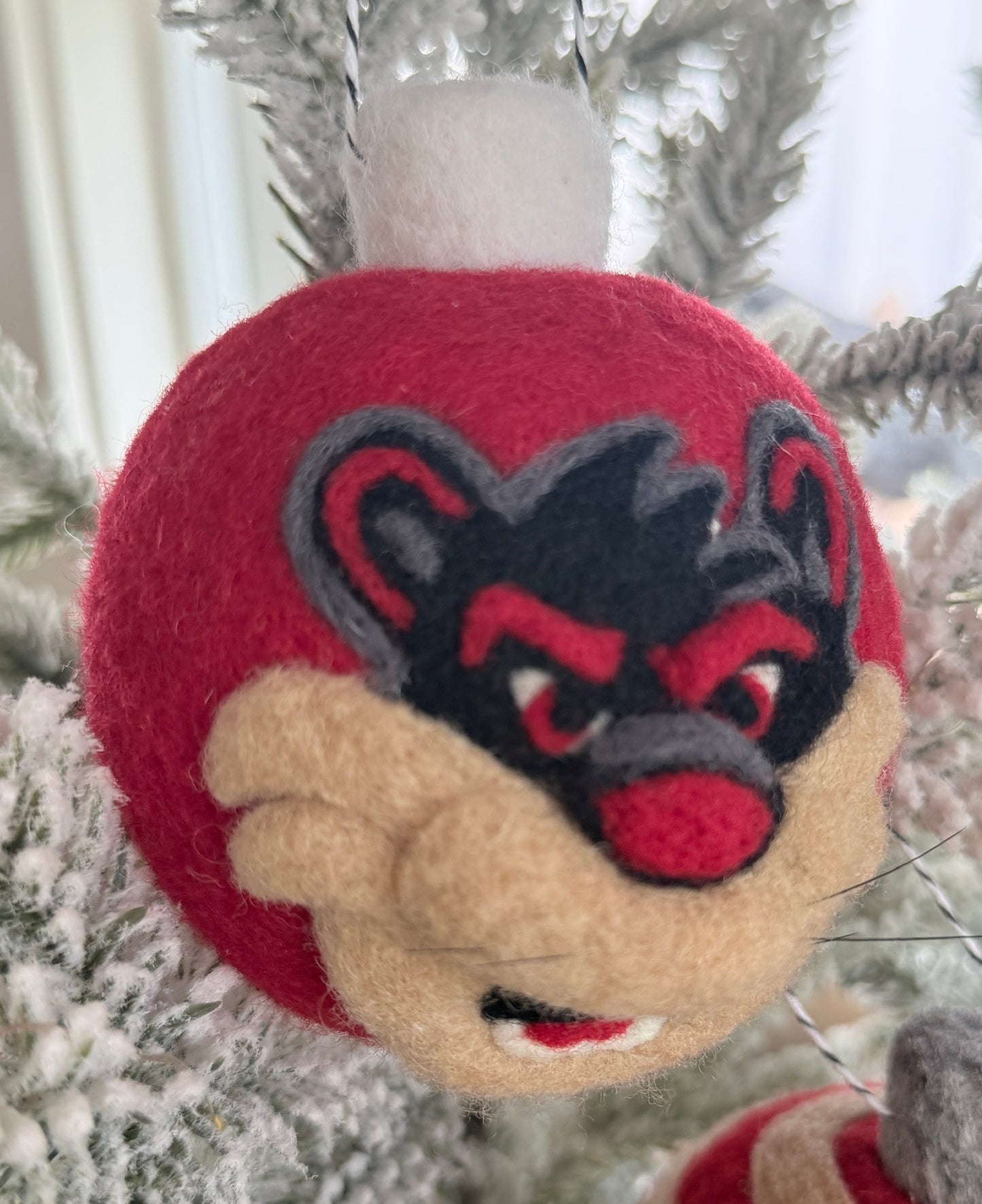 UC Red ornamnet with 2-D Bearcat on one side and pawprint on the other